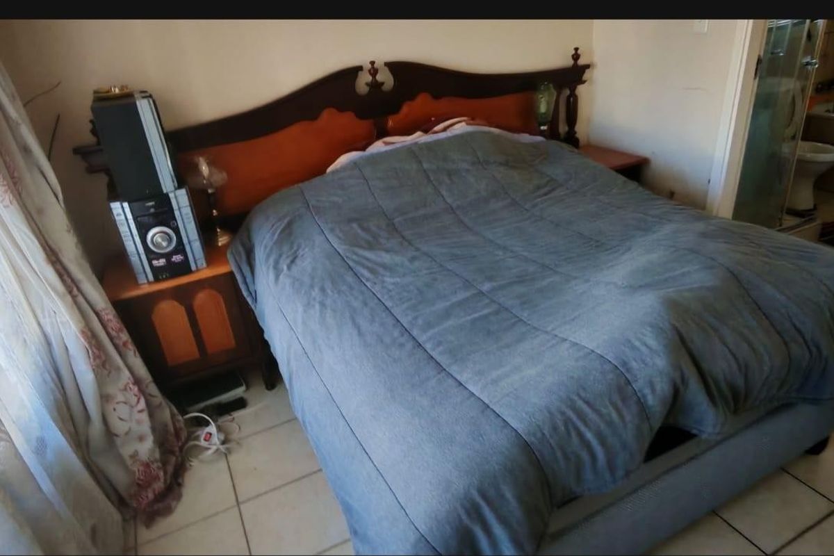 A bedroom featuring tiled flooring and direct access to an en-suite bathroom.