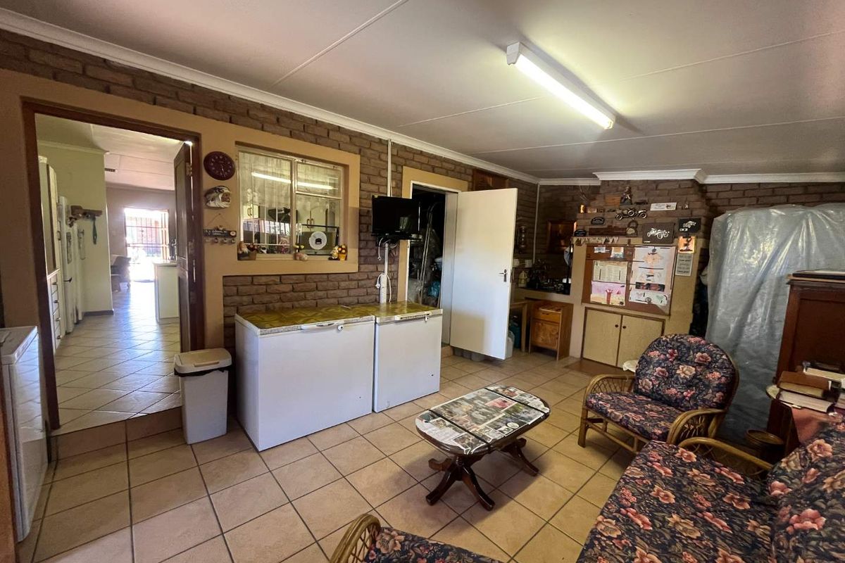 A living area featuring exposed brick walls and tiled flooring, providing a functional space with potential for modernization and improved layout.