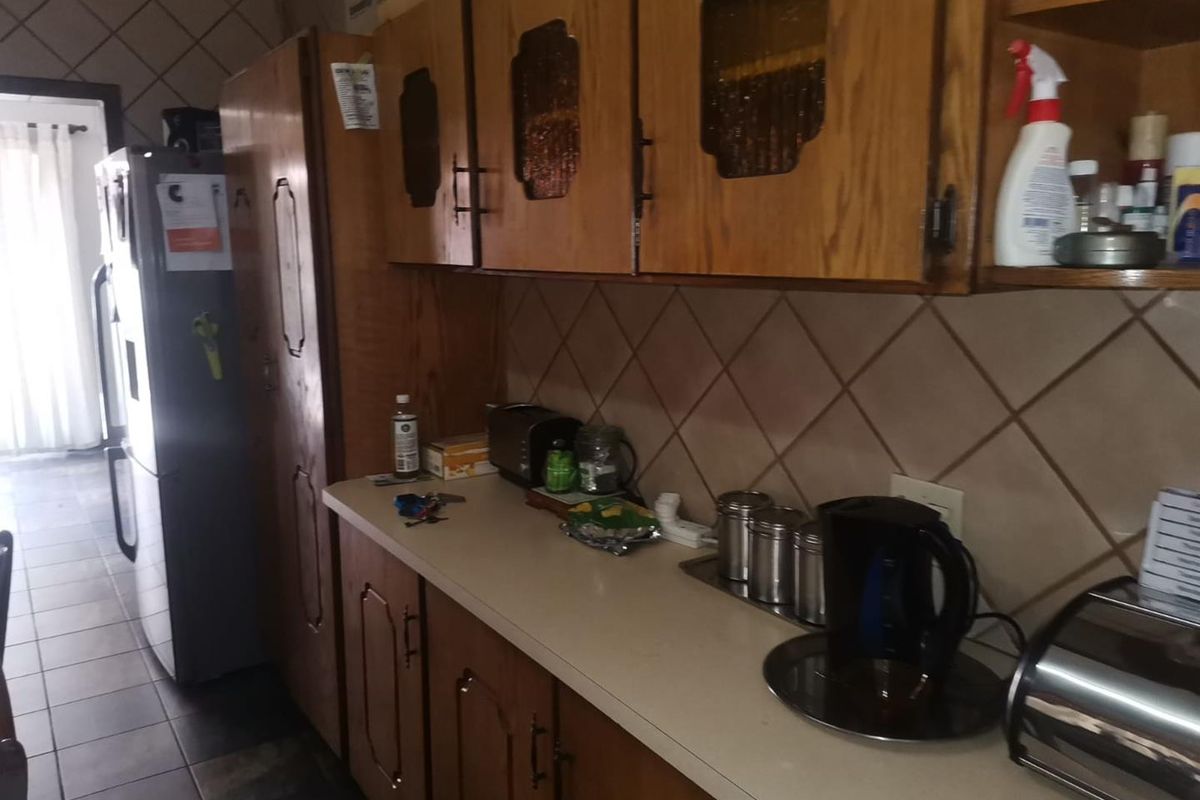 A functional kitchen featuring traditional timber cabinetry, a tiled backsplash, and ample counter space, providing a classic foundation for future updates.