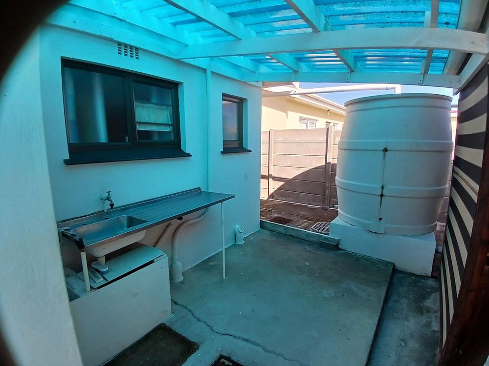 We have just stepped outside the rear door. Extra washing facility on our left. On our right we have 2 more Areas: the Study and another under roof Area. 2 Water Tanks.