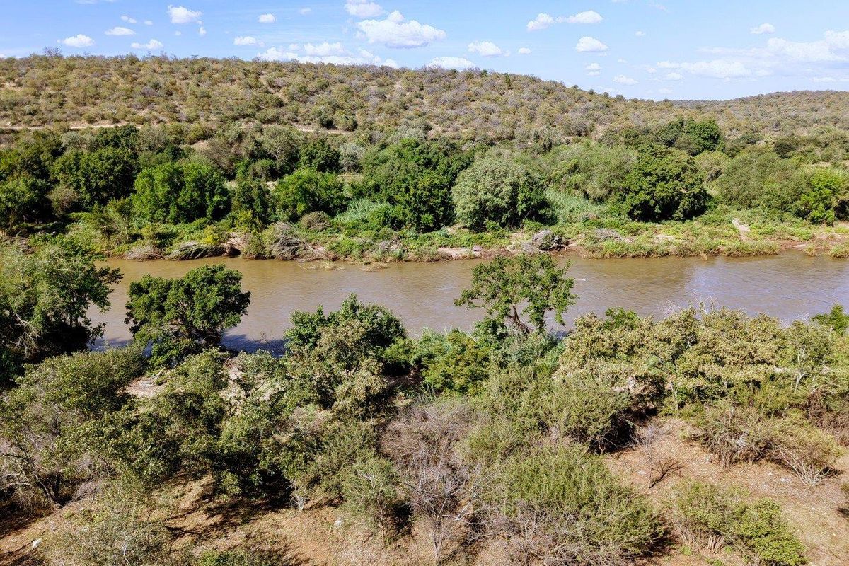 An aerial view of the vacant residential land featuring natural river frontage, indigenous vegetation, and scenic landscape views.