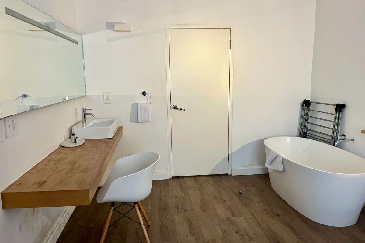 Modern bathroom featuring a freestanding bathtub, floating vanity with a vessel sink, and a large wall-mounted mirror.