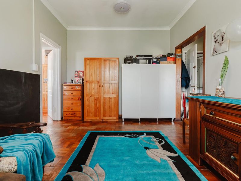 A living room featuring classic parquet flooring and coved ceilings, offering a neutral base ready for modern updates and personal styling.