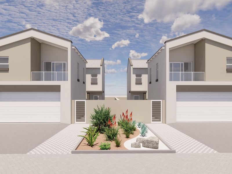 Modern townhouse exterior featuring double garages, upper-level balconies with glass balustrades, and a neatly landscaped front garden area.