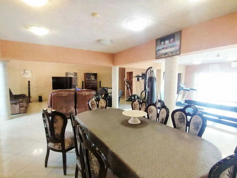 Spacious open-plan living and dining area featuring tiled flooring and structural columns, offering a versatile layout for family living and entertainment.