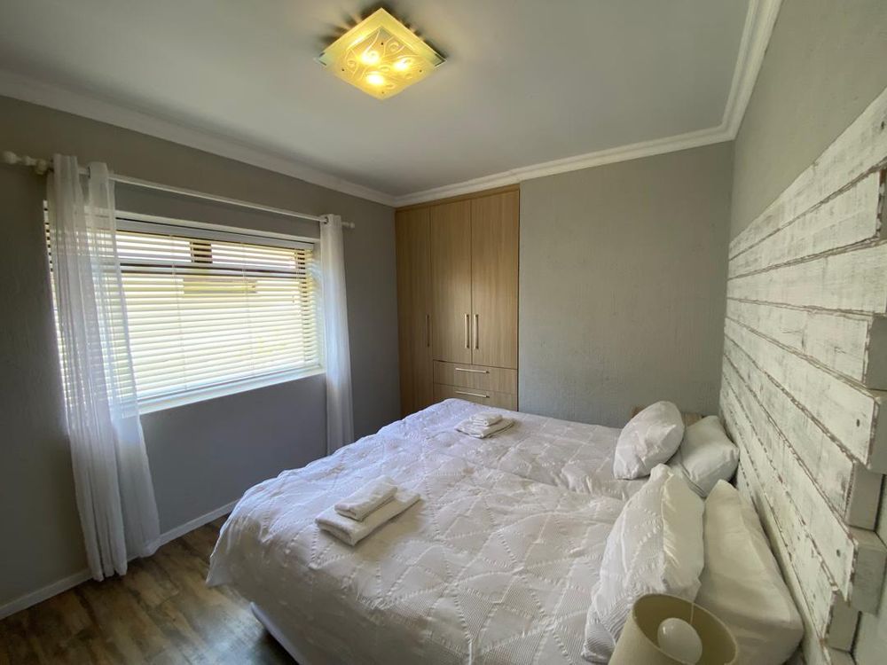 Ground floor, bedroom 2 with built-in cupboards and en-suite bathroom. 