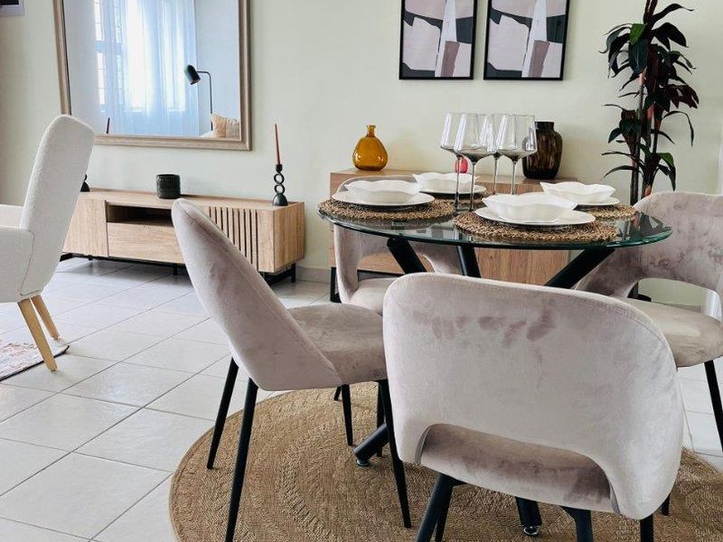 A bright dining area featuring neutral wall tones and light-colored ceramic floor tiles, creating a clean and inviting space for meals.