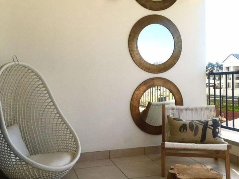 A covered balcony featuring tiled flooring and a metal balustrade, offering an open-air space suitable for relaxation.