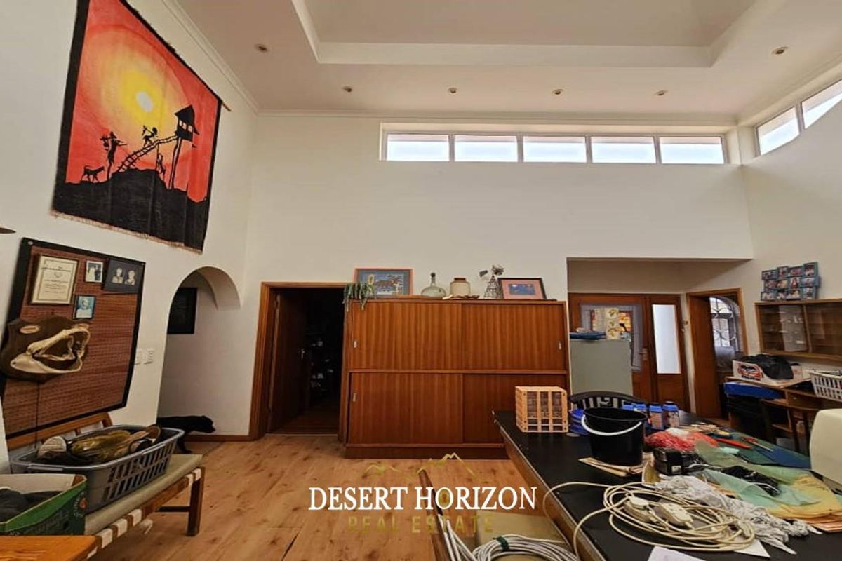 Spacious living area featuring high ceilings with recessed lighting, clerestory windows, and wood-look flooring, providing an open and airy atmosphere.