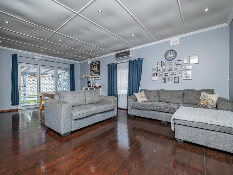 Spacious living room featuring polished hardwood floors, recessed lighting, and direct access to the outdoor patio area through sliding glass doors.