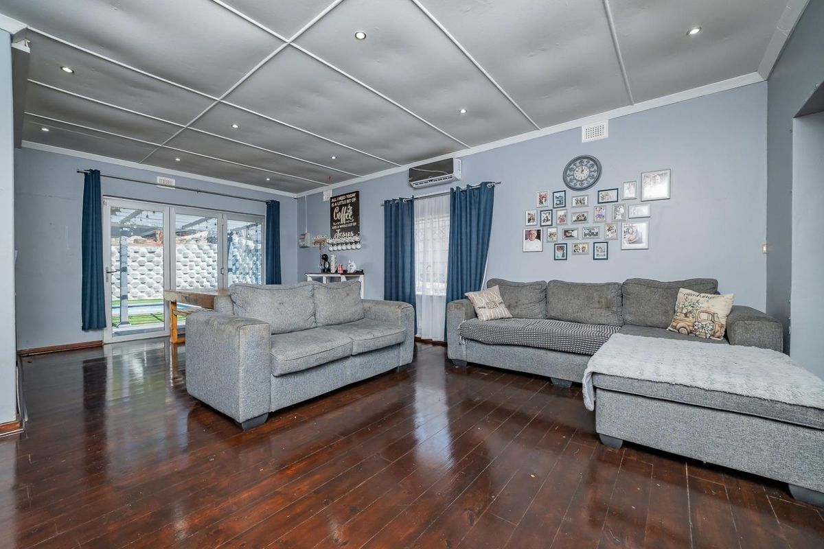 Spacious living room featuring polished hardwood floors, recessed lighting, and direct access to the outdoor patio area through sliding glass doors.