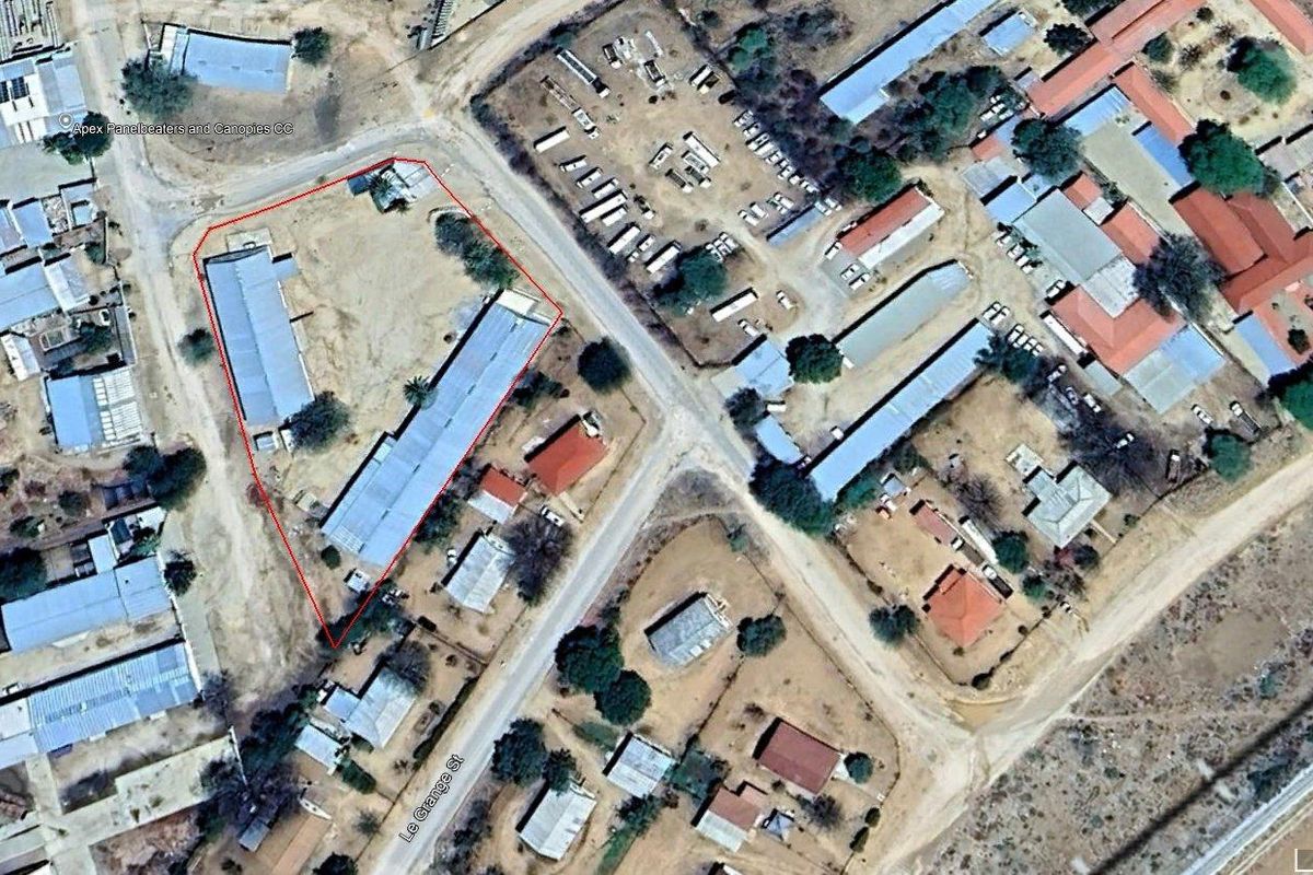 Aerial view of a commercial property site with existing structures, highlighting the layout and street access.