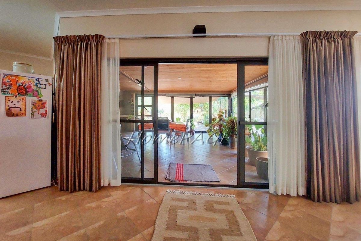 View from the living area through large sliding glass doors into a covered patio space with tiled flooring.