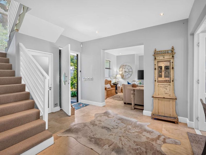 Welcoming entrance foyer featuring tiled flooring, a staircase with a white balustrade, and direct access to the main living area.