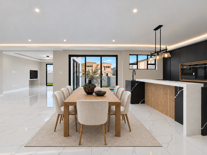 Modern open-plan living and dining area featuring high-end finishes, marble-look flooring, recessed lighting, and a sleek kitchen with a waterfall island.