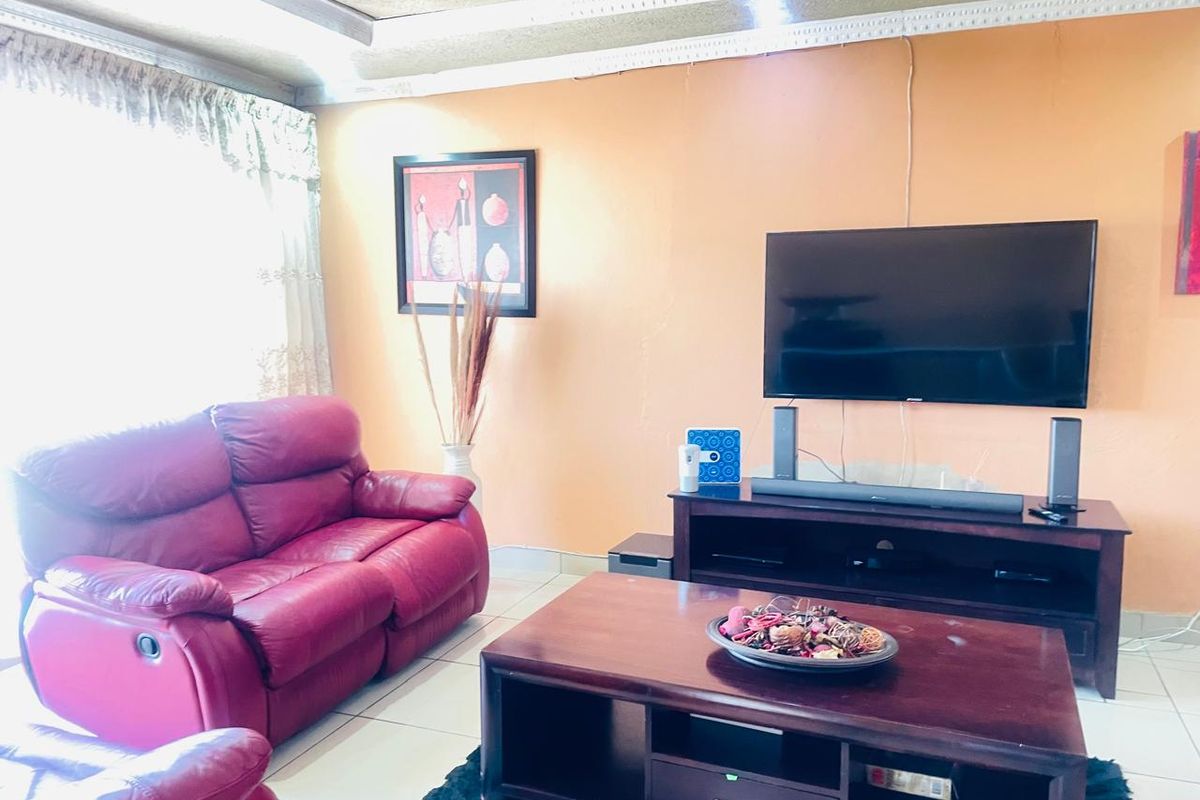 A living room featuring tiled flooring and a textured ceiling, providing a functional space for relaxation and entertainment.