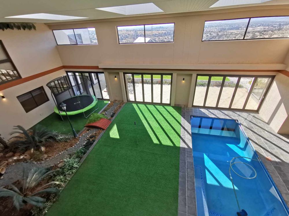 TOP FLOOR LOOKING DOWN TO THE INDOOR GARDEN WITH POOL