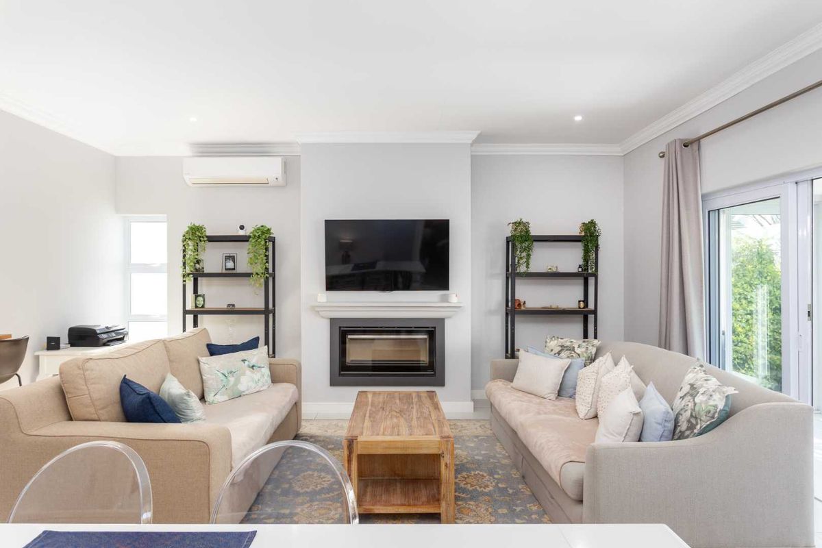 A bright and inviting living room featuring a built-in fireplace, wall-mounted air conditioning unit, and sliding glass doors leading to the outdoors.