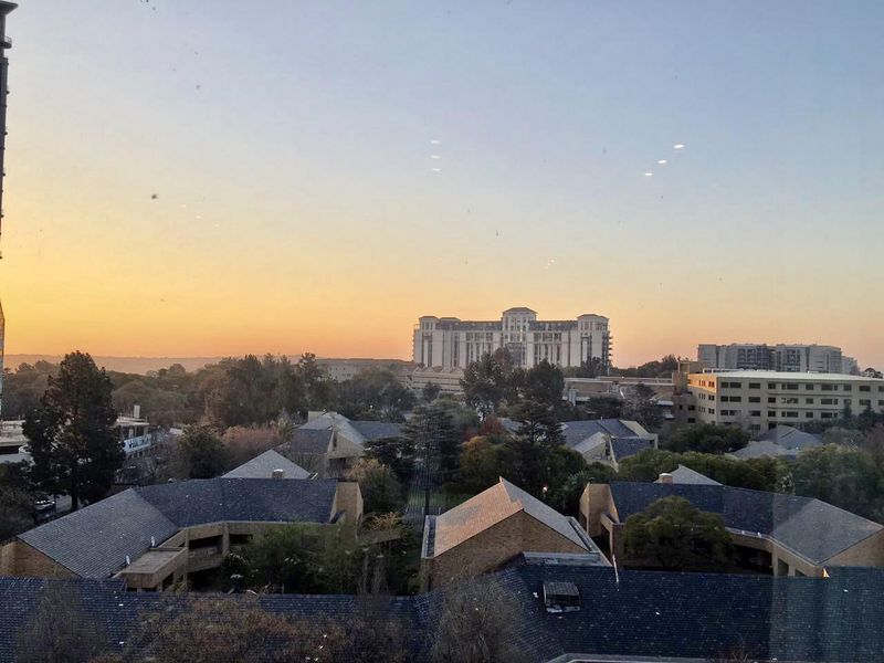 A scenic elevated view overlooking the surrounding neighbourhood and urban landscape at sunset.