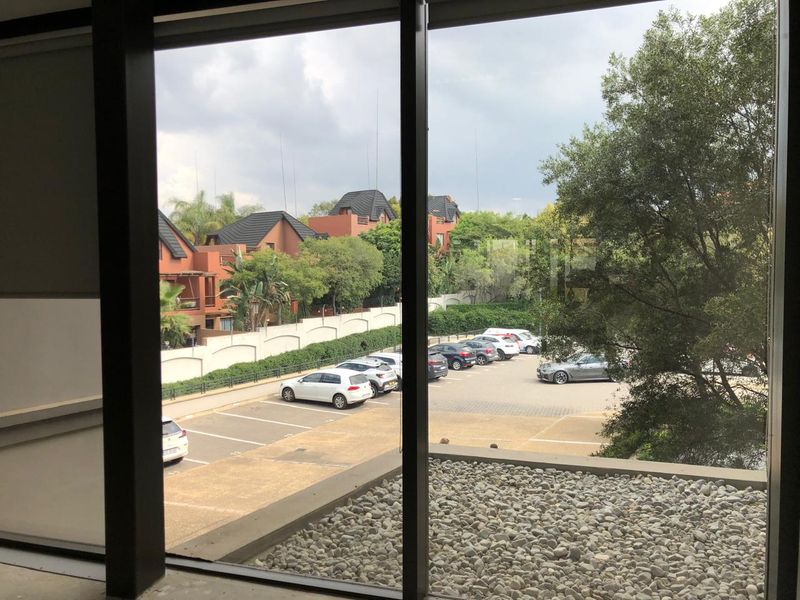View from an office window overlooking a parking area and residential complex.