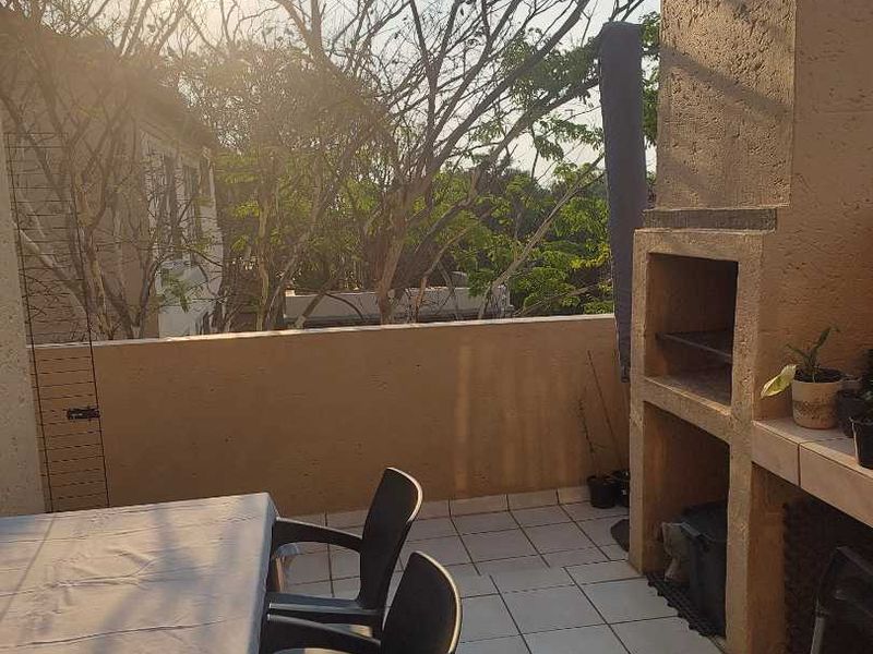 A balcony area featuring a built-in braai and tiled flooring, offering an outdoor space suitable for entertaining.