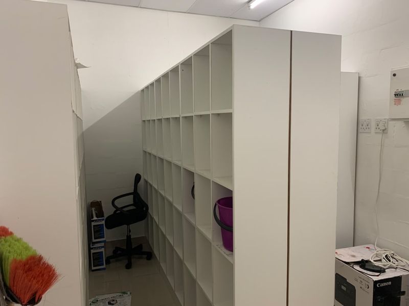 A functional utility or storage space featuring built-in shelving units, electrical distribution board, and standard power outlets.