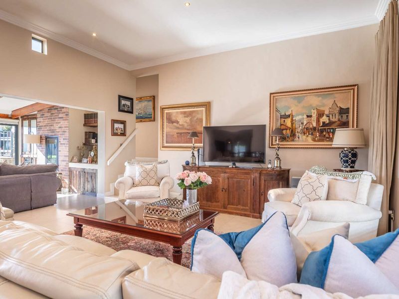 Spacious living room featuring tiled floors, recessed lighting, and a cozy brick fireplace area, creating a warm and inviting atmosphere.
