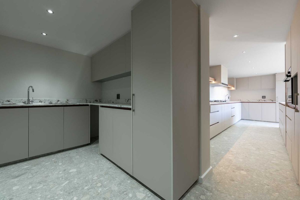 Modern, minimalist kitchen featuring sleek cabinetry, stone countertops, integrated appliances, and recessed lighting in a clean, open-plan layout.