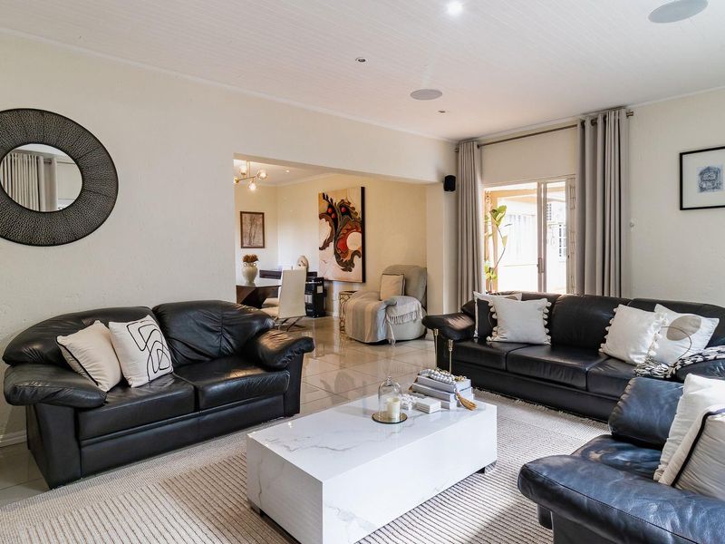 Spacious living room featuring tiled flooring, recessed ceiling lighting, and direct access to an outdoor area through sliding glass doors.