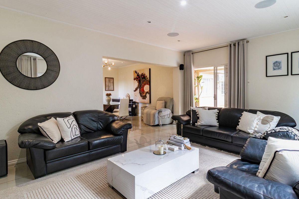 Spacious living room featuring tiled flooring, recessed ceiling lighting, and direct access to an outdoor area through sliding glass doors.