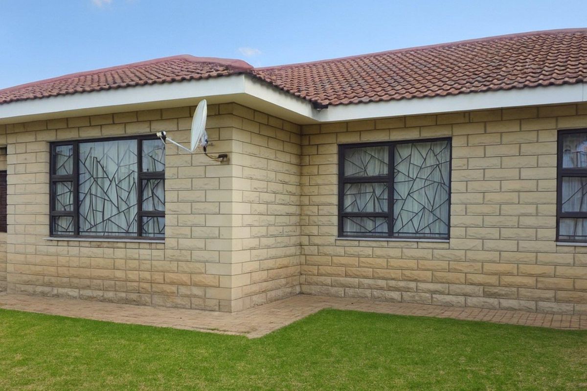 Exterior view of the house featuring face brick walls, tiled roof, and security bars on the windows.
