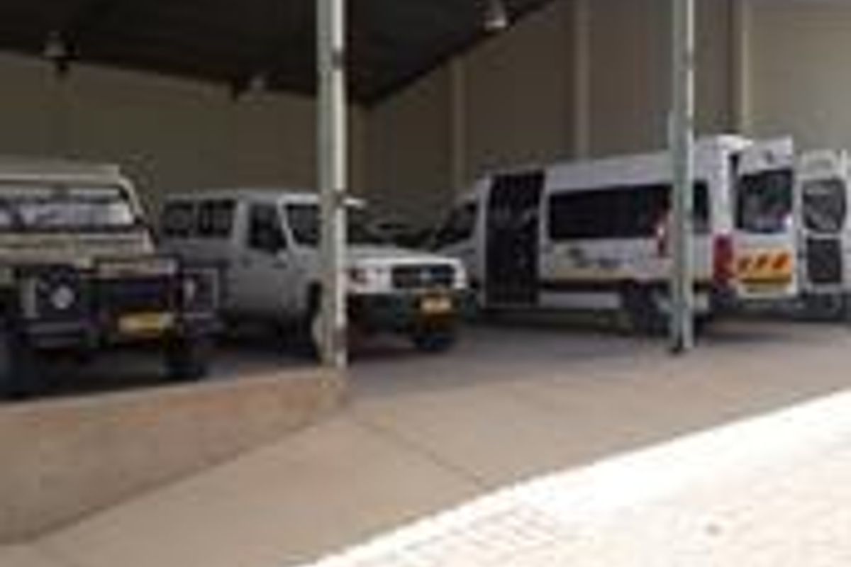 A large industrial covered parking or loading bay featuring a steel portal frame structure and concrete hardstand area.