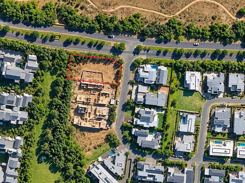Aerial view of a vacant residential plot situated within a developed estate, highlighting its location and surrounding infrastructure.