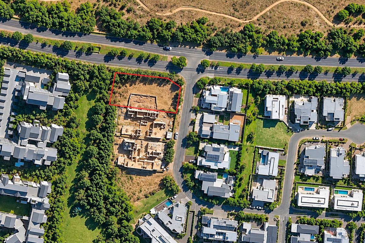 Aerial view of a vacant residential plot situated within a developed estate, highlighting its location and surrounding infrastructure.