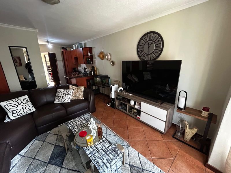 Open-plan living area featuring terracotta floor tiles and an integrated kitchen space, providing a functional layout for daily living.