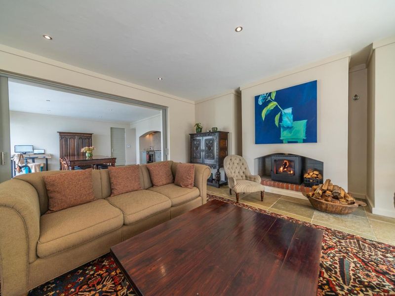 Spacious living room featuring a built-in fireplace with a stone hearth, recessed lighting, and large sliding doors connecting to the adjacent dining area.
