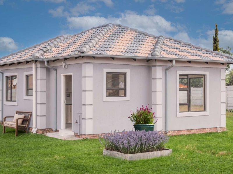 A well-maintained detached dwelling featuring a tiled roof, plastered exterior walls, and aluminium window frames, set within a neat garden.