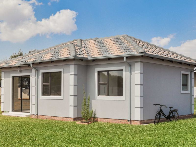 A well-maintained single-story house exterior featuring a tiled roof, grey rendered walls, aluminium window frames, and a sliding glass door leading to the garden.