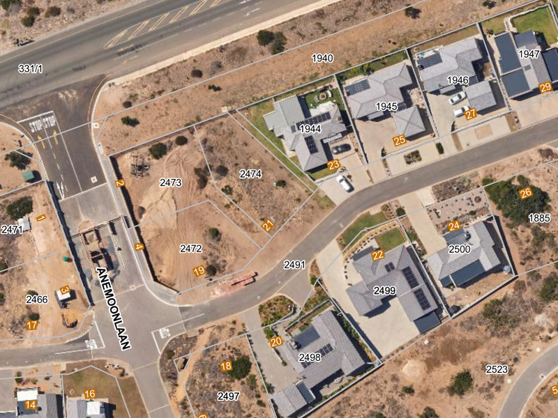 Aerial view of a residential estate showing vacant land plots and existing housing developments with clear cadastral boundary lines.
