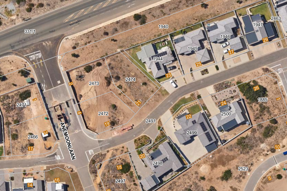 Aerial view of a residential estate showing vacant land plots and existing housing developments with clear cadastral boundary lines.