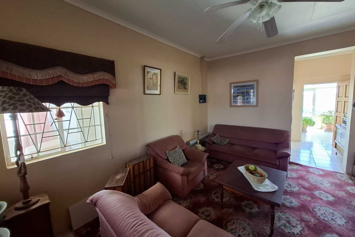 A living room featuring a ceiling fan and access to an adjacent tiled patio area.