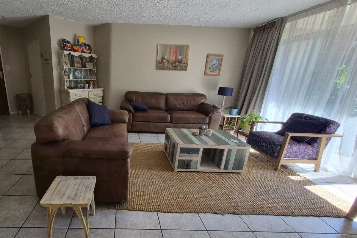A spacious living room featuring large sliding glass doors that provide ample natural light and access to the outdoor area.