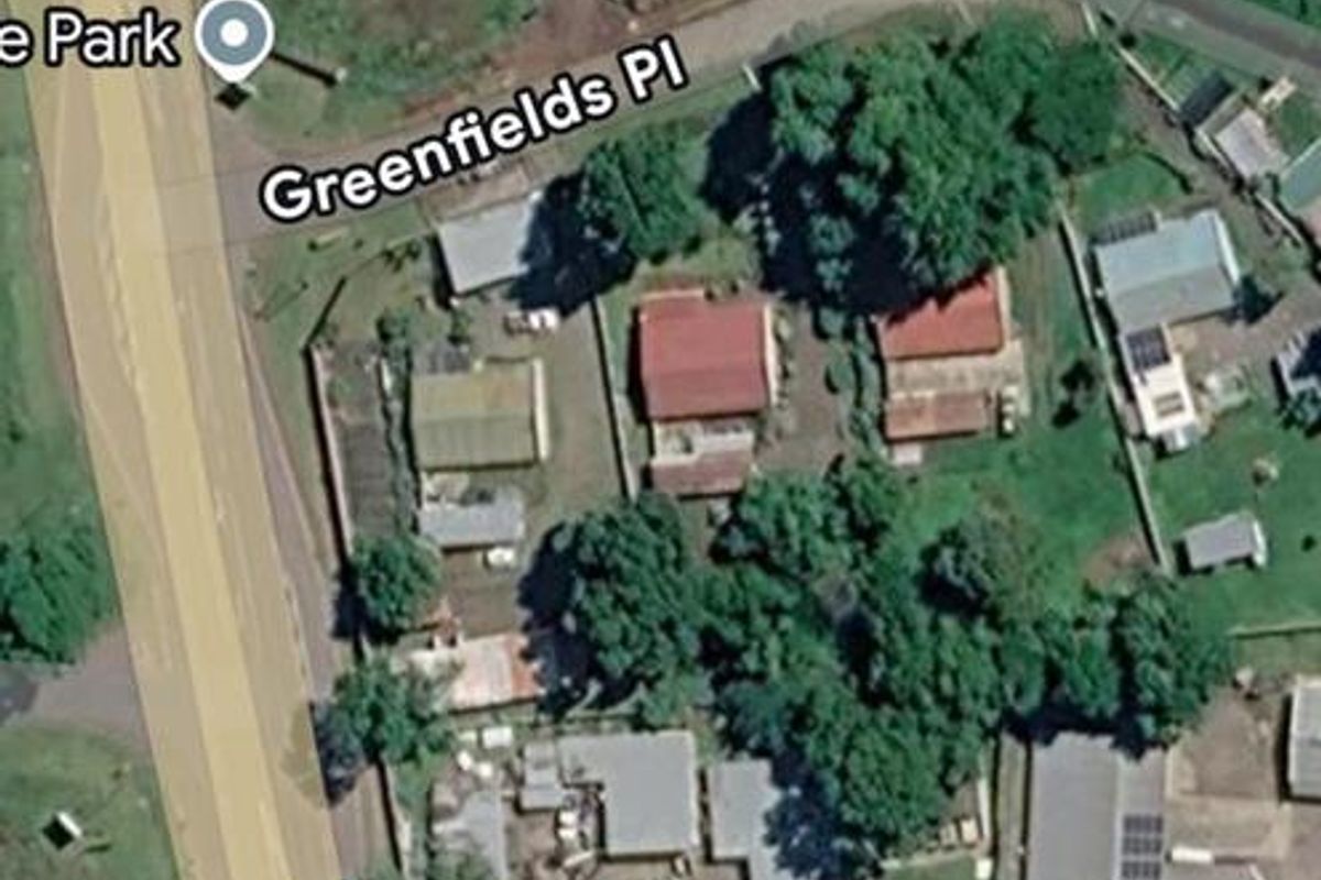 An aerial satellite view of the property and surrounding neighborhood, showing the site layout and access from the main road.