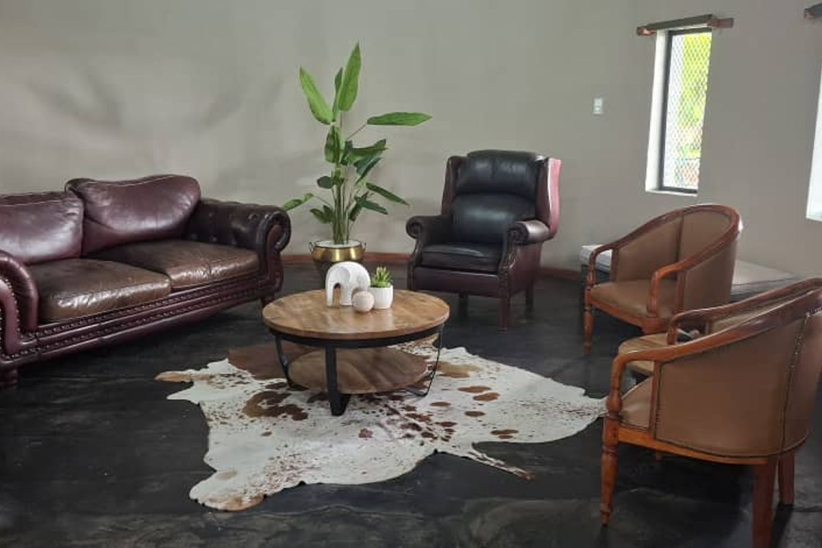 A spacious living area featuring polished concrete floors and multiple windows, providing a bright and open atmosphere.