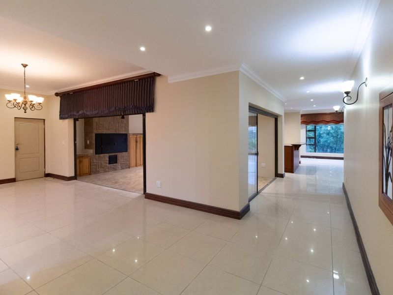 Spacious open-plan living area featuring polished tile floors, recessed lighting, a built-in fireplace, and elegant stained glass accents, offering a bright and versatile layout.