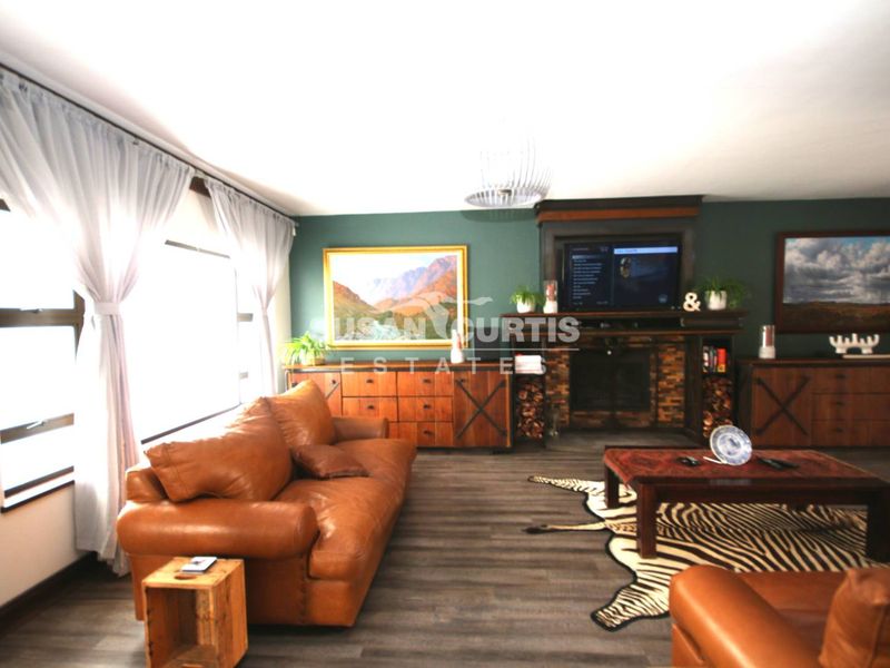 A comfortable living room featuring a prominent built-in fireplace with dark wood surround and modern laminate flooring.