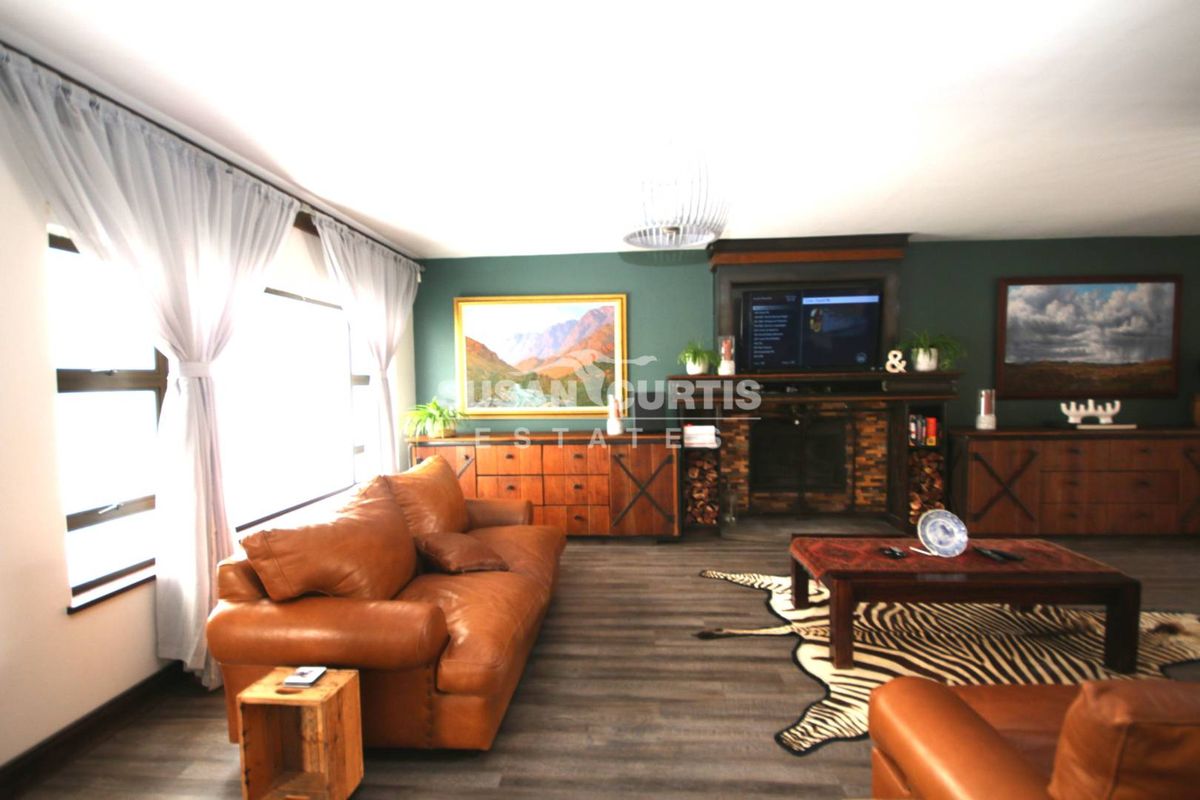 A comfortable living room featuring a prominent built-in fireplace with dark wood surround and modern laminate flooring.