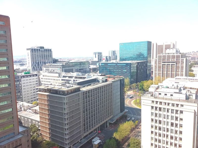 An elevated city skyline view showcasing surrounding commercial office buildings and urban infrastructure.