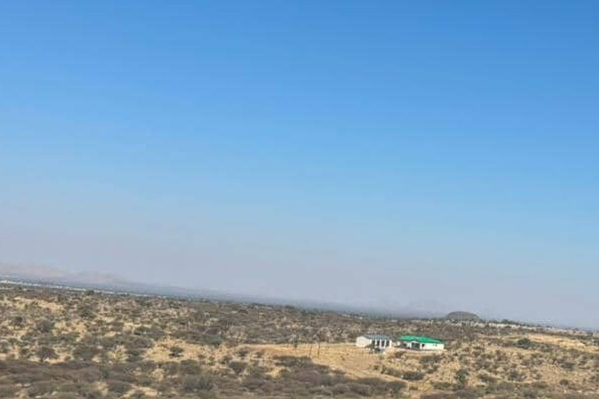 An aerial view of the expansive rural small holding landscape, showcasing the vast open terrain and distant horizon.
