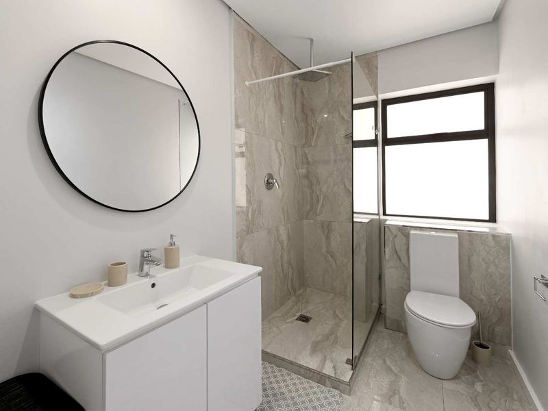 Modern bathroom featuring a sleek vanity, walk-in shower with glass enclosure, and contemporary tiling throughout.